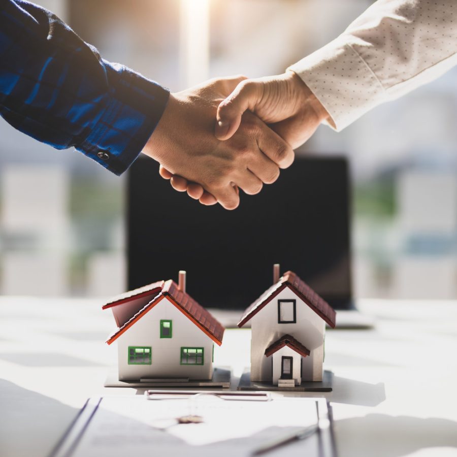 Real estate agents shake hands after the signing of the contract agreement is complete.